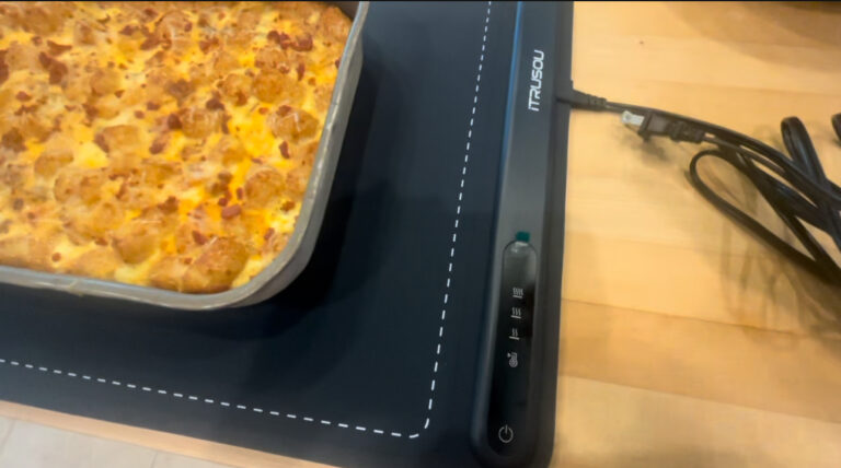 Electric warming tray with casserole dish keeping food warm on a kitchen counter
