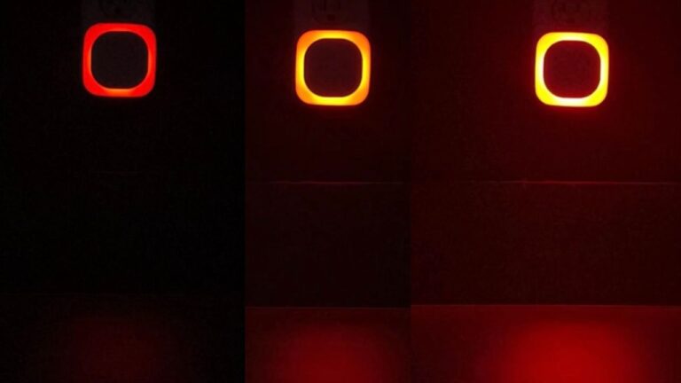 Dimmable red night light glowing softly on a bedroom wall near a nightstand