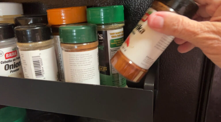 Magnetic spice racks on the side of a refrigerator holding labeled spice jars