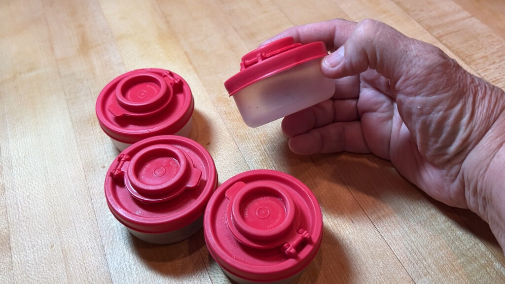 Compact salt and pepper shakers filled with spices, ready for travel or camping