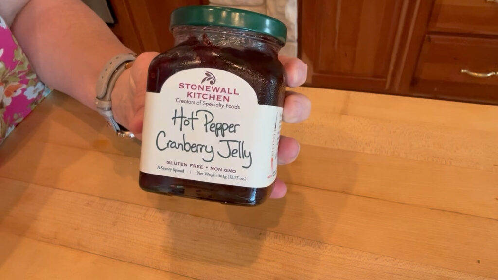 Stonewall Kitchen Hot Pepper Cranberry Jelly spread over a cheese ball with crackers.