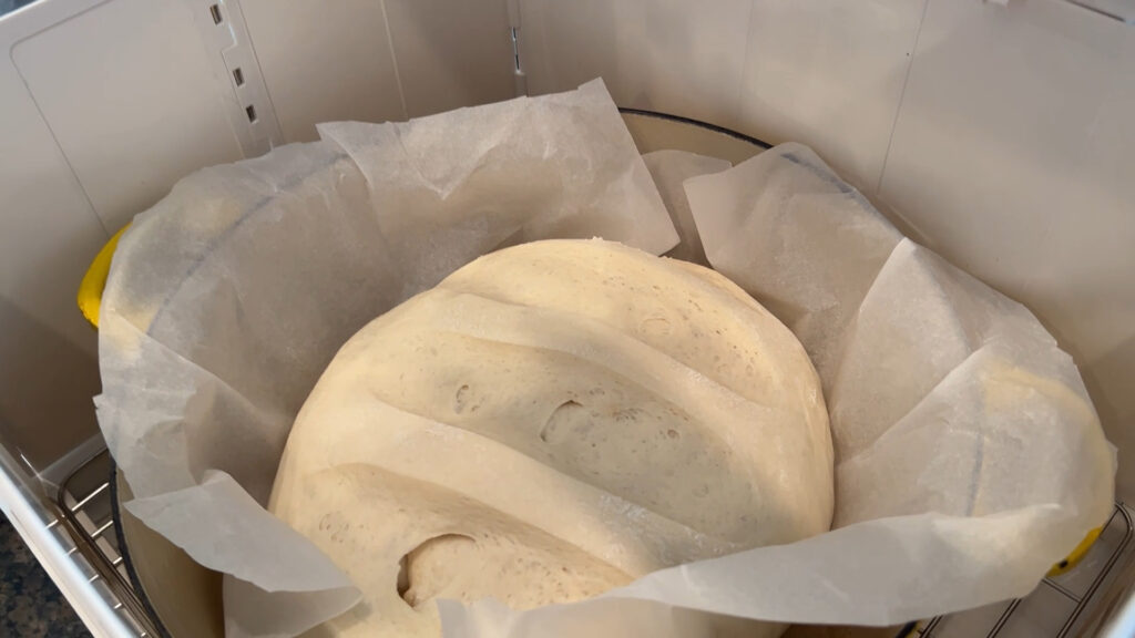 Folding bread proofer and slow cooker set up with pan inside.