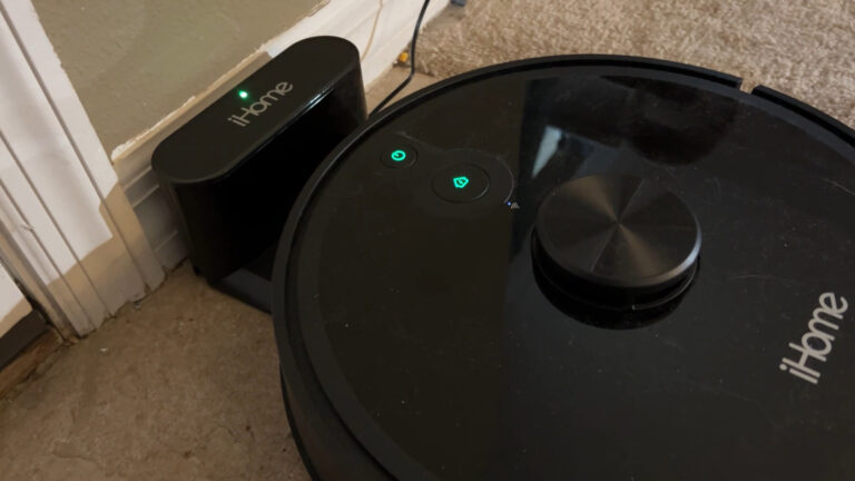 Robot vacuum cleaning hardwood floor and returning to its base.