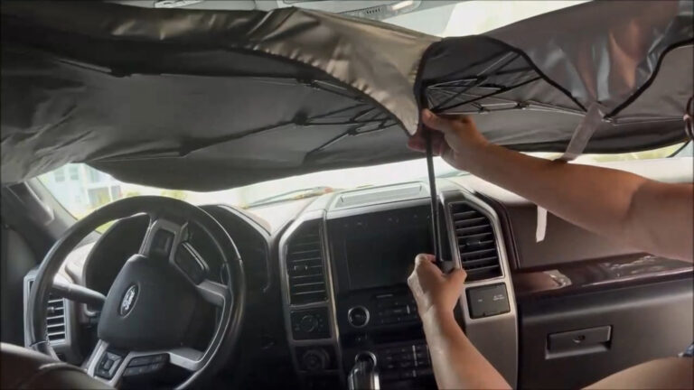 Car windshield sun shade unfolded across a truck windshield.