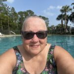 Jen smiling at the edge of a swimming pool while rebuilding motivation after cancer treatment