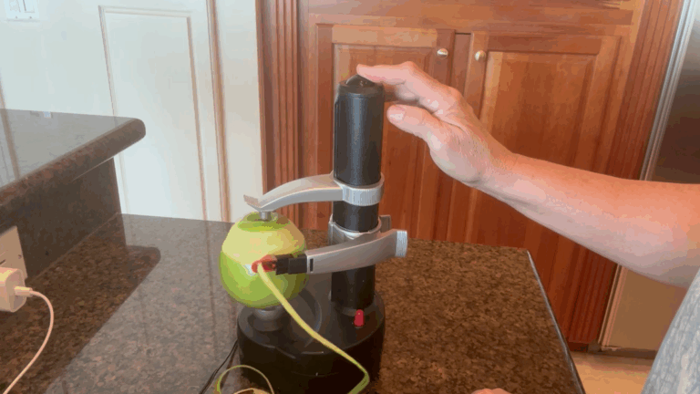 Electric peeler peeling an apple automatically on kitchen counter.