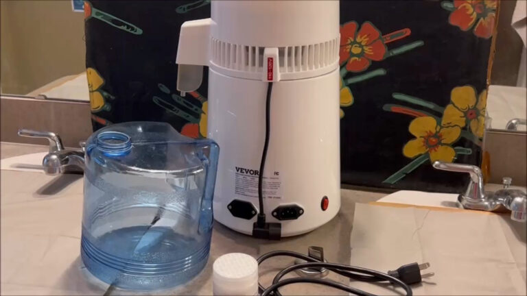 Home water distiller with stainless steel tank and clear glass water container.