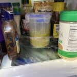 Clear plastic pickle jar with lift-out strainer basket and locking lid on kitchen counter